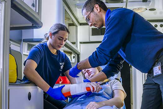paramedics mending a broken arm in an ambulance