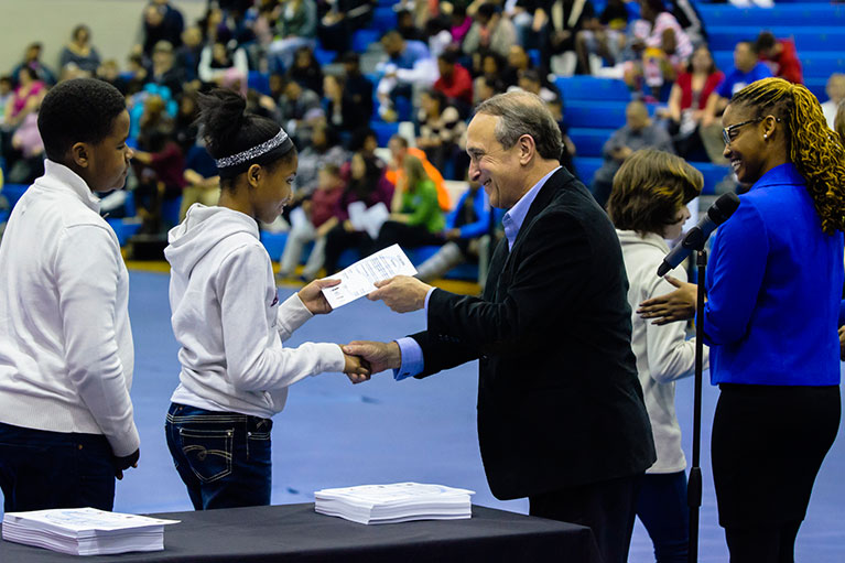 A highschool student accepts a certificate from LCC's President, Dr. Brent Knight