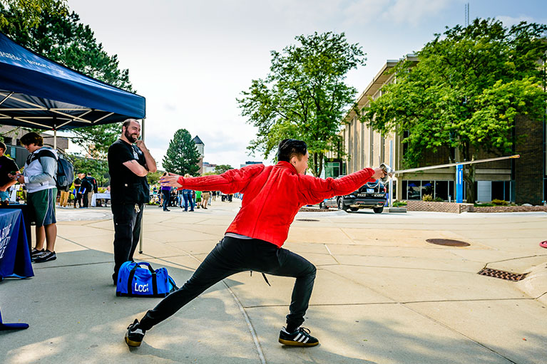 Student demonstrates fencing stance on the Washington Mall