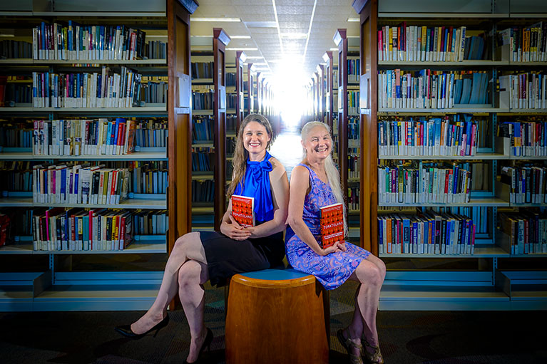 Librarians sit together among rows of books
