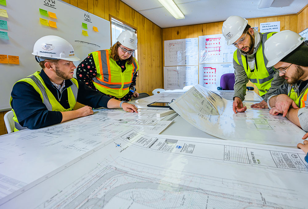 group discussing project around a table inside building at construction site