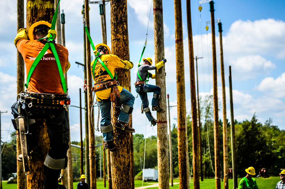 students climbing up on some of the lcc training utility poles at west campus