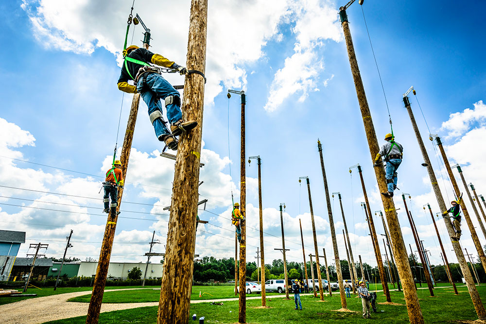 students climbing up on on some of the lcc training utility poles at west campus