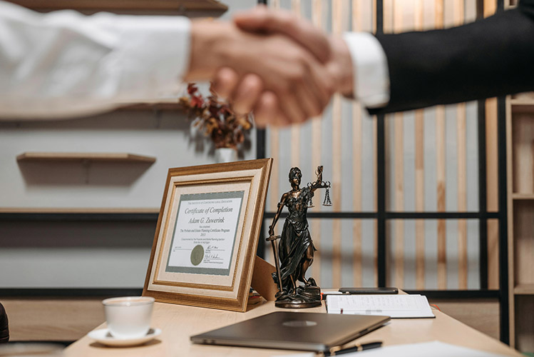 People shaking hands over a desk