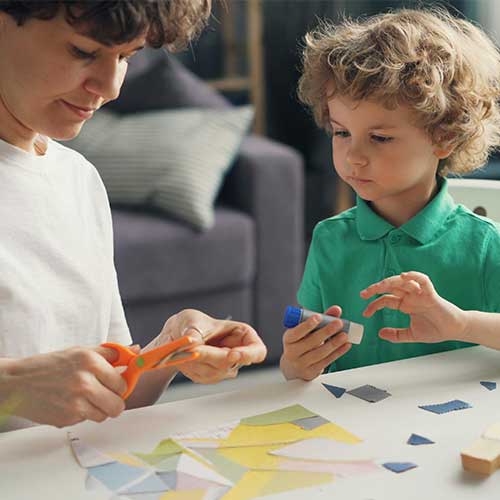 Teen helping child with crafts