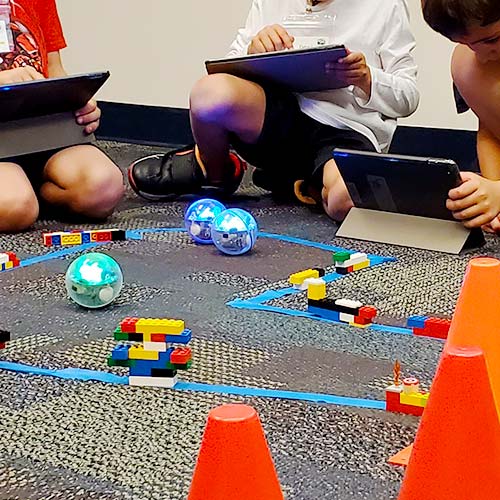Students with ball robots in obstacle course
