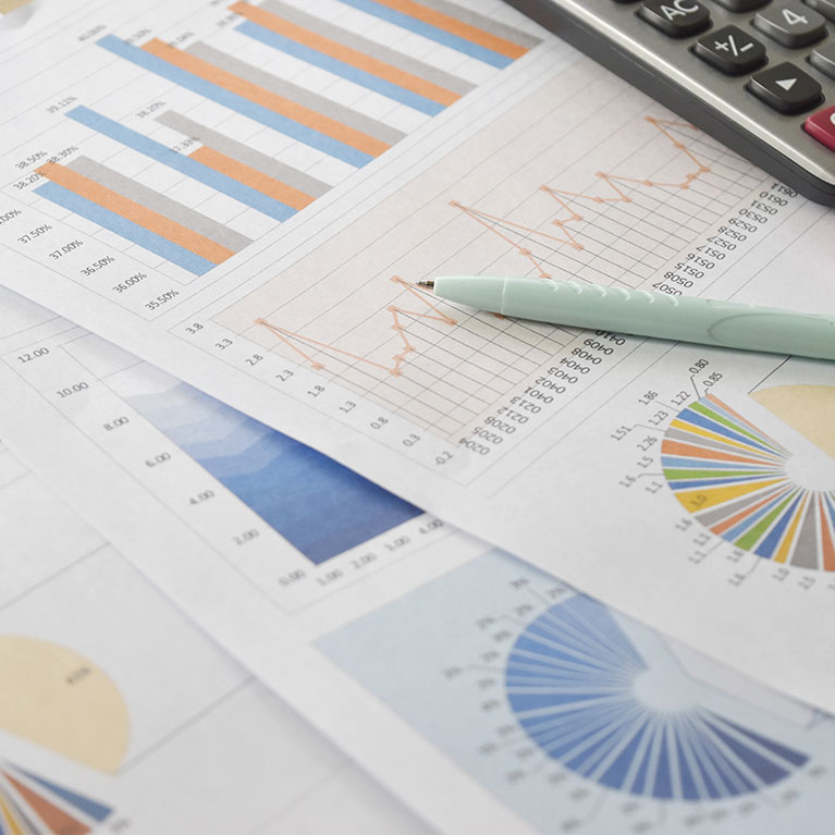 charts, calculator, and a pencil on top of a table