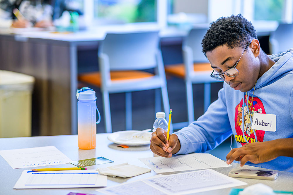 student at a table writing