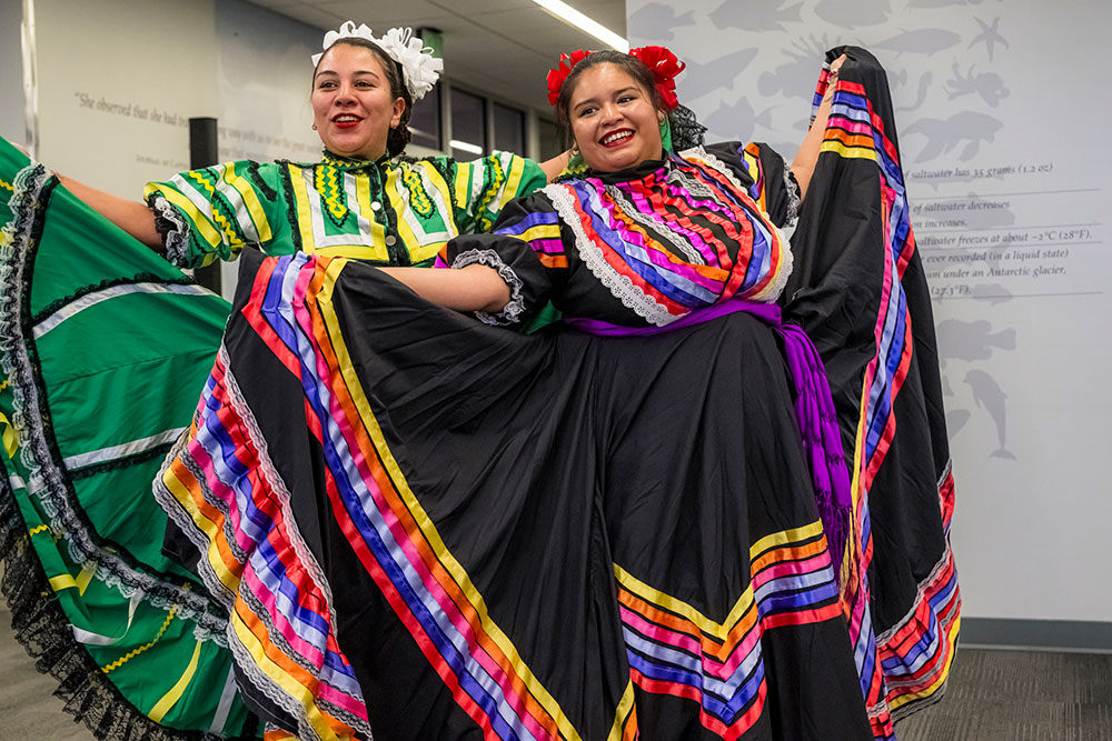 two women with colorful dresses dancing at an event