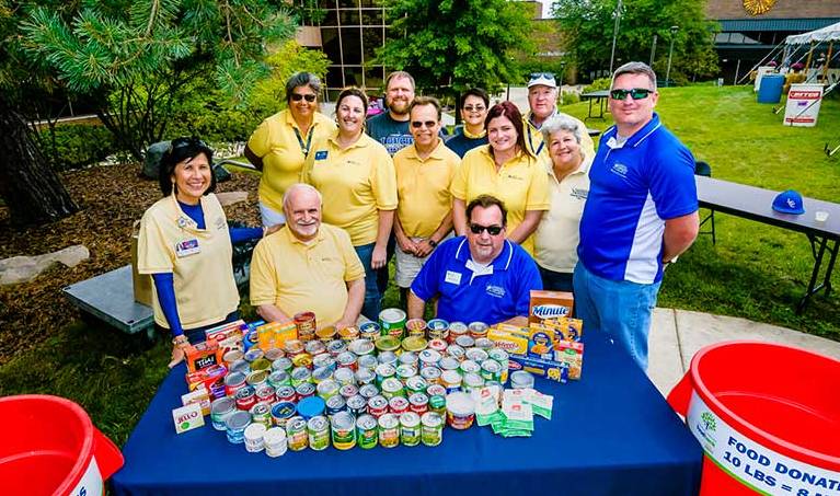 employees at a table with canned goods 