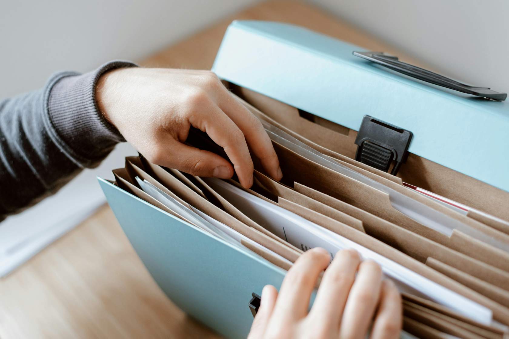 hands grabbing files out of a filing cabinet