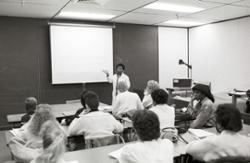 Instructor Lillie Christian teaches from the front of a classroom.