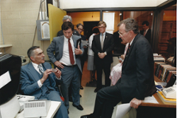 Vice President George H.W. Bush sitting on a desk in the Vocational Technical section of the Gannon Building.