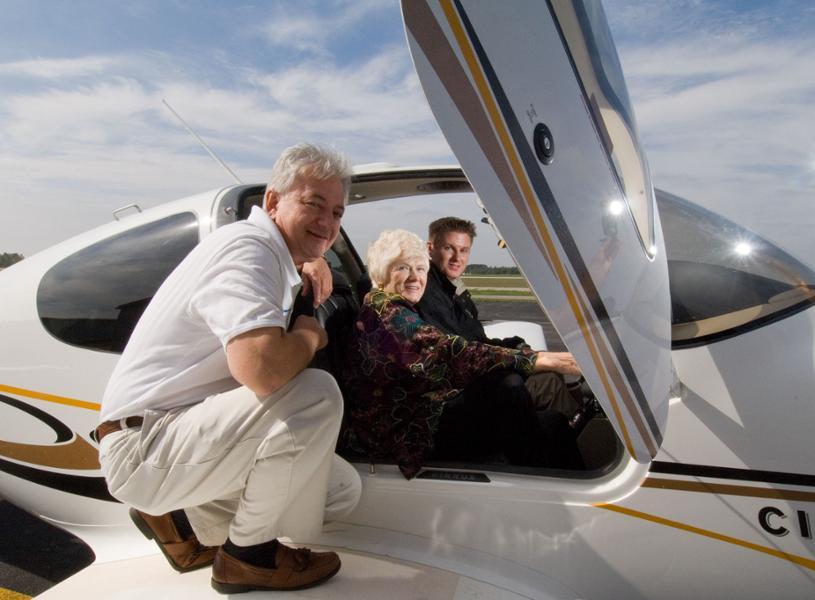 two people inside a plane and one on the wing