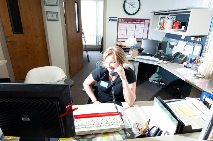 employee sitting at a desk talking on her office phone