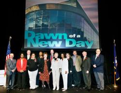 People standing together on stage at the opening event for the new health services building at the downtown campus.