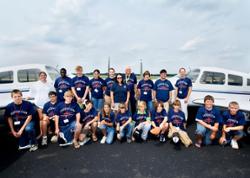 Participants in the 2006 youth Aviation Camp pose by two Piper Cherokee Warrior airplanes.