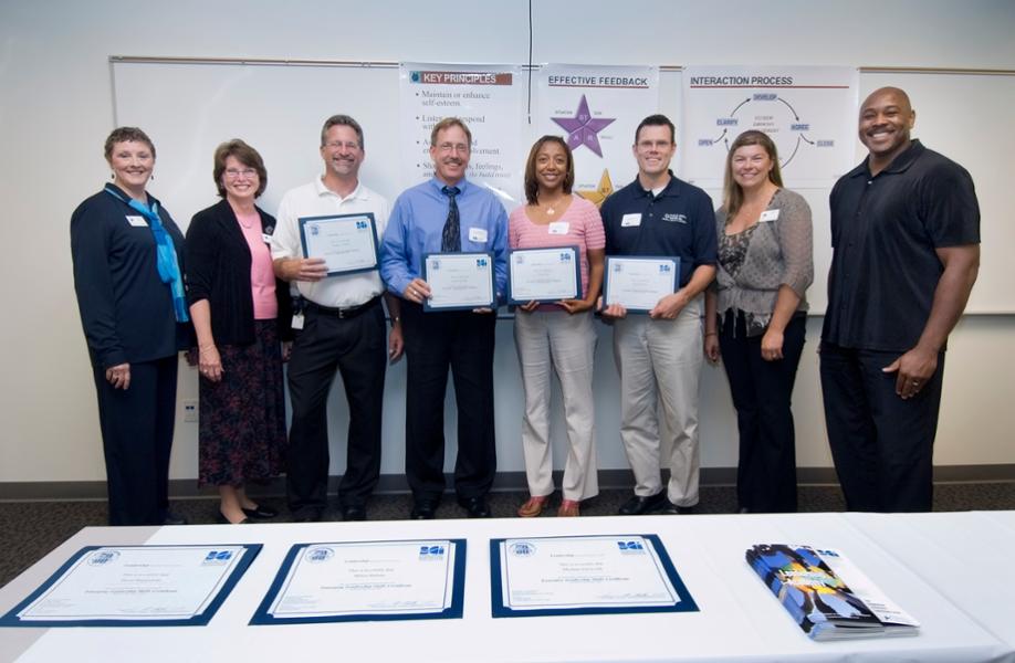 Participants of the BCI Leadership Skills Academy stand with LCC staff while holding their completion certificates.