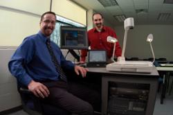 Two staff members from the Information Technology Services (ITS) Division set up new audio-visual (AV) equipment in a classroom.