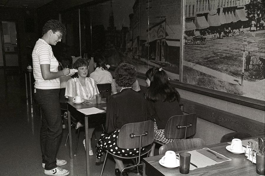 A student working in the small restaurant in the Old Central Building, taking food order