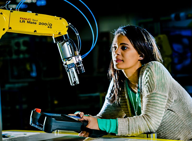 Student working a robot machine