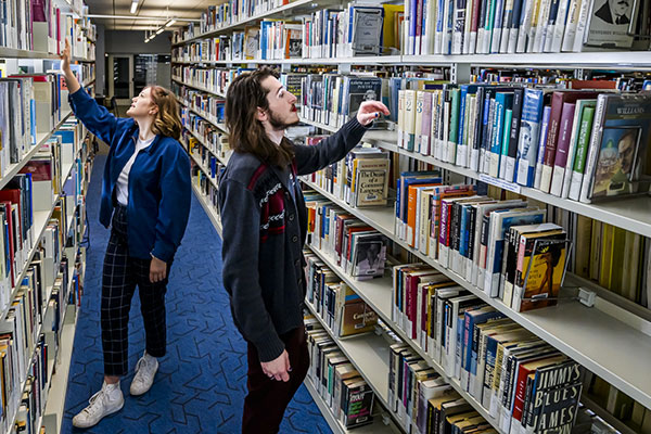 students looking for books in the library