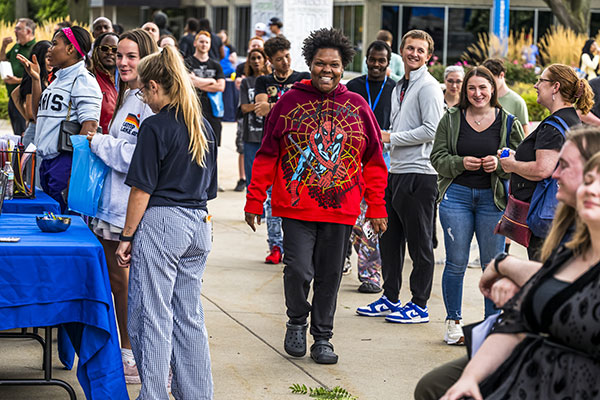 students in the downtown mall, visiting tables and talking