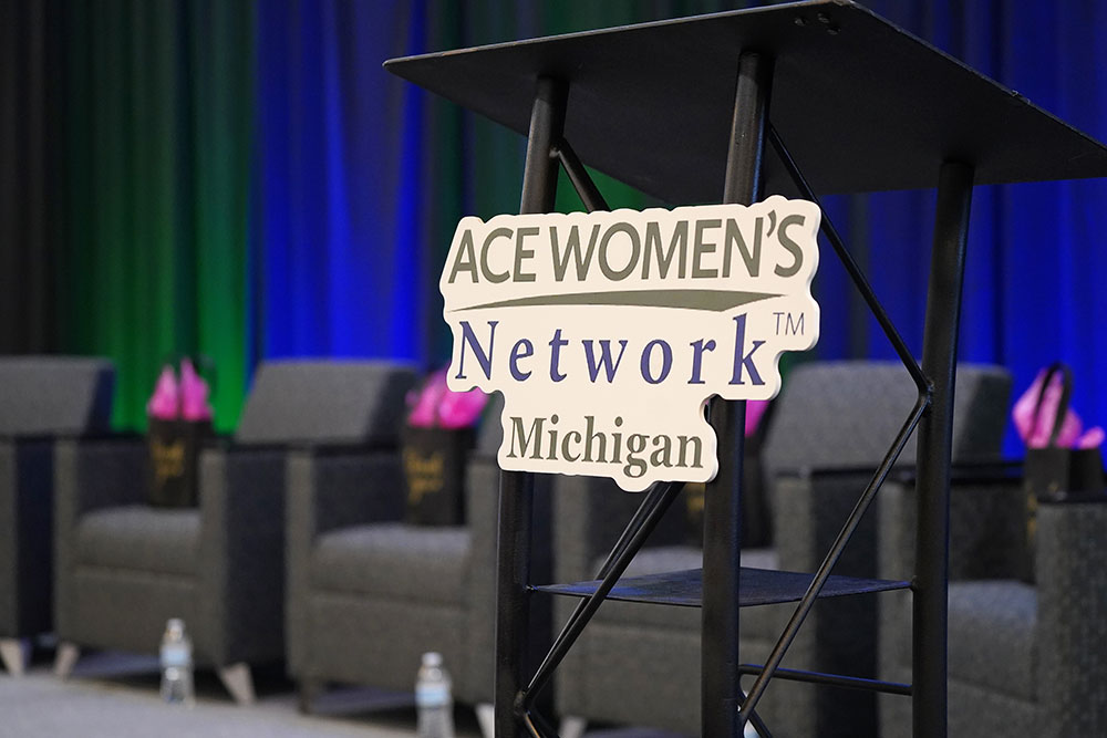 ace women's network michigan logo on a podium on stage