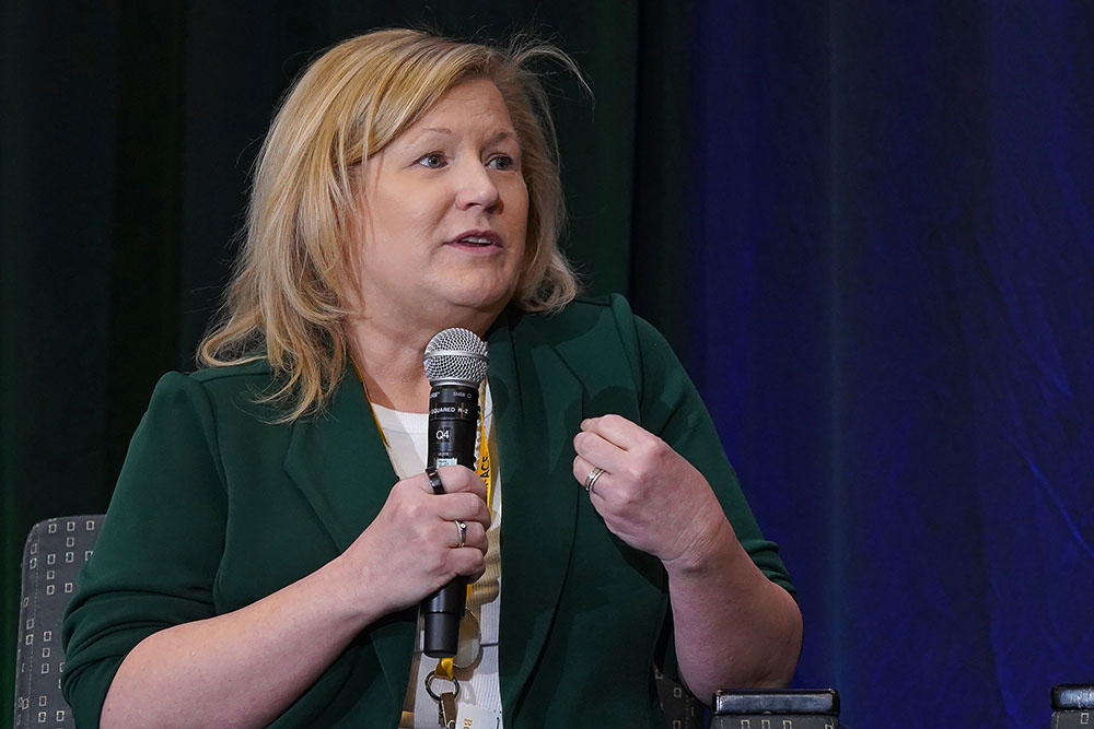 woman holding a microphone and speaking at an ace conference